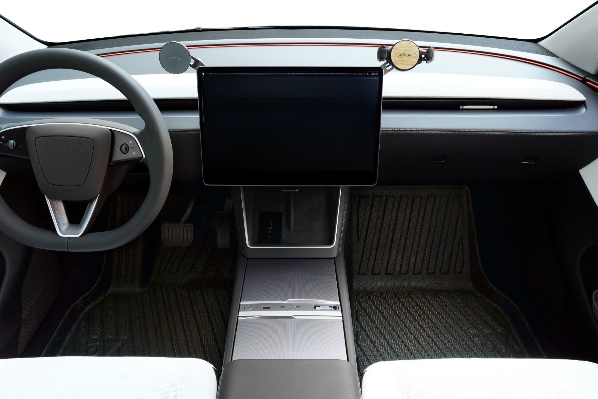 Minimalist car interior with a large central touchscreen, left-side steering wheel, clean dashboard lines, visible JOWUA Model Y 2025+ Interior / Trunk Full Coverage Liner Combo All-Weather Floor Liners, and white seats at the bottom corners.