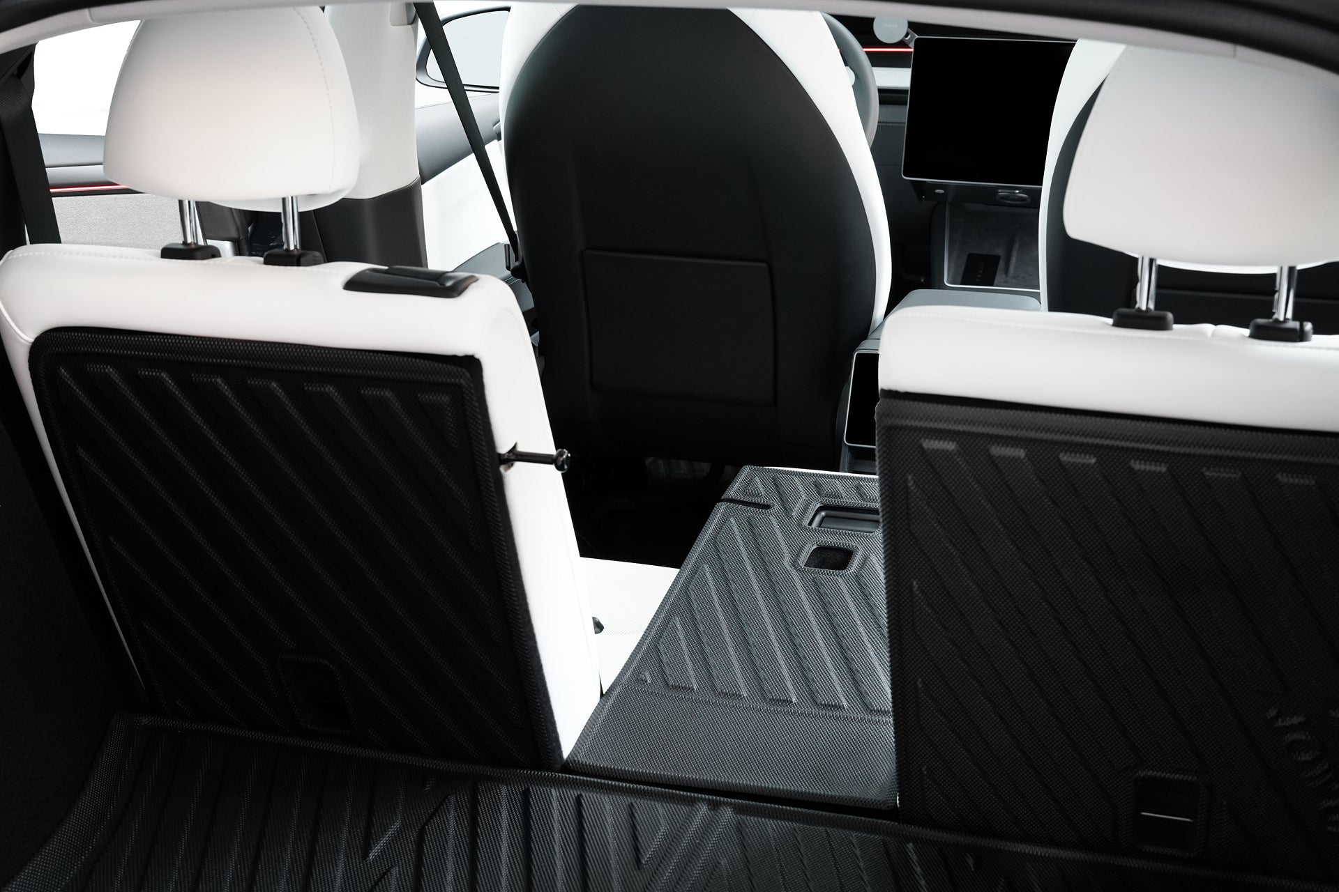 View from the trunk of a modern car with folded rear seats, revealing a flat cargo area lined with the JOWUA Model Y 2025+ Interior / Trunk Full Coverage Liner Combo for maximized storage and sleek minimalist design.