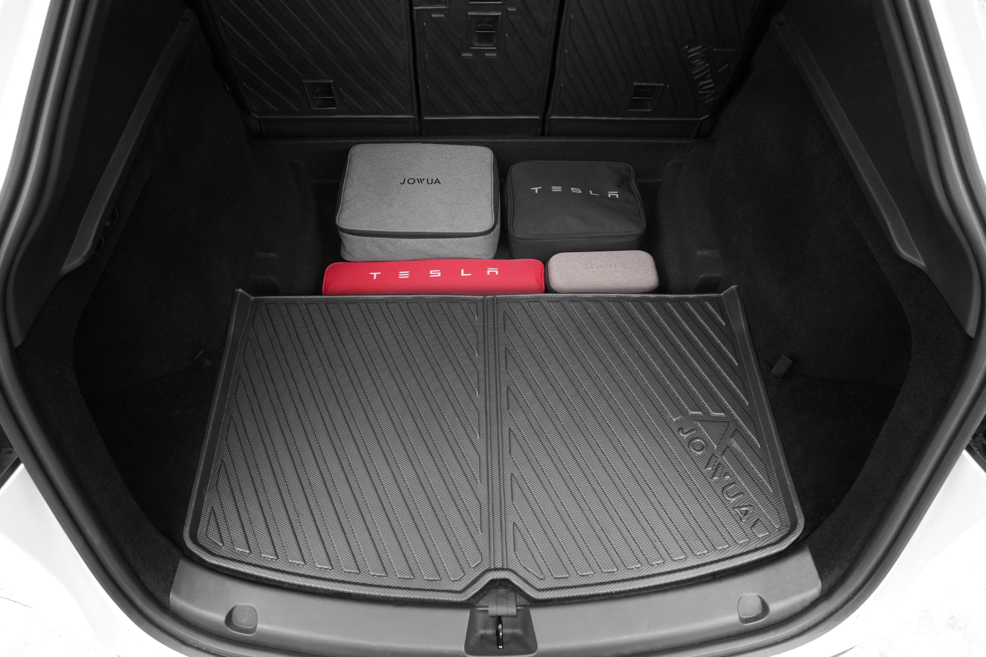Open the trunk of a Tesla Model Y featuring the JOWUA Model Y EasyShield Waterproof Trunk Liner + Rear Seats Back Cover Bundle and four storage bags—two labeled 