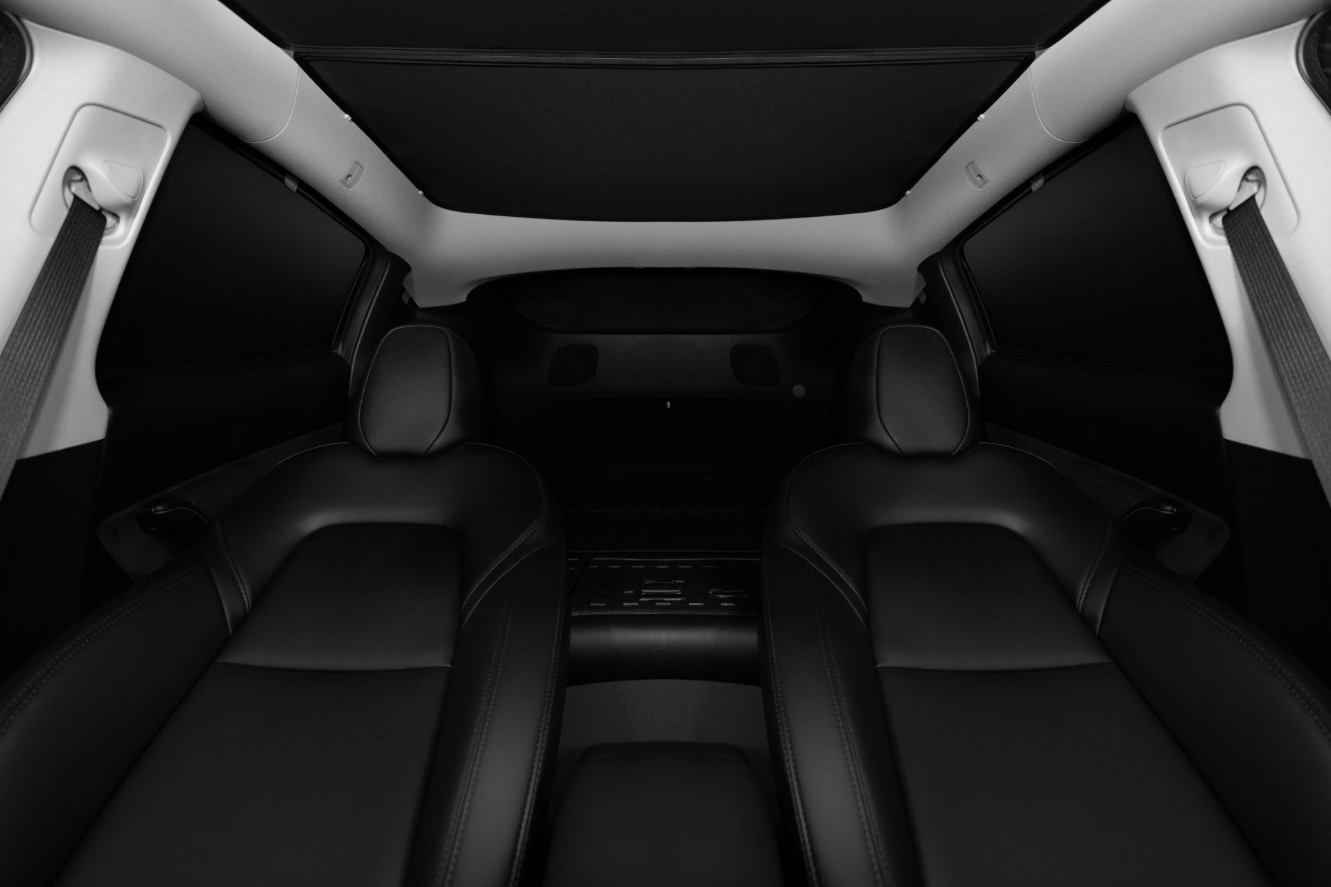 Interior view of a modern car showcasing two sleek, black leather front seats. While the dashboard and steering wheel remain hidden, the minimalist design emphasizes luxury and comfort. A JOWUA Side + Rear Liftgate Window Sunshade for Model Y provides added privacy and security, with dark materials lining the ceiling and sides of the cabin.