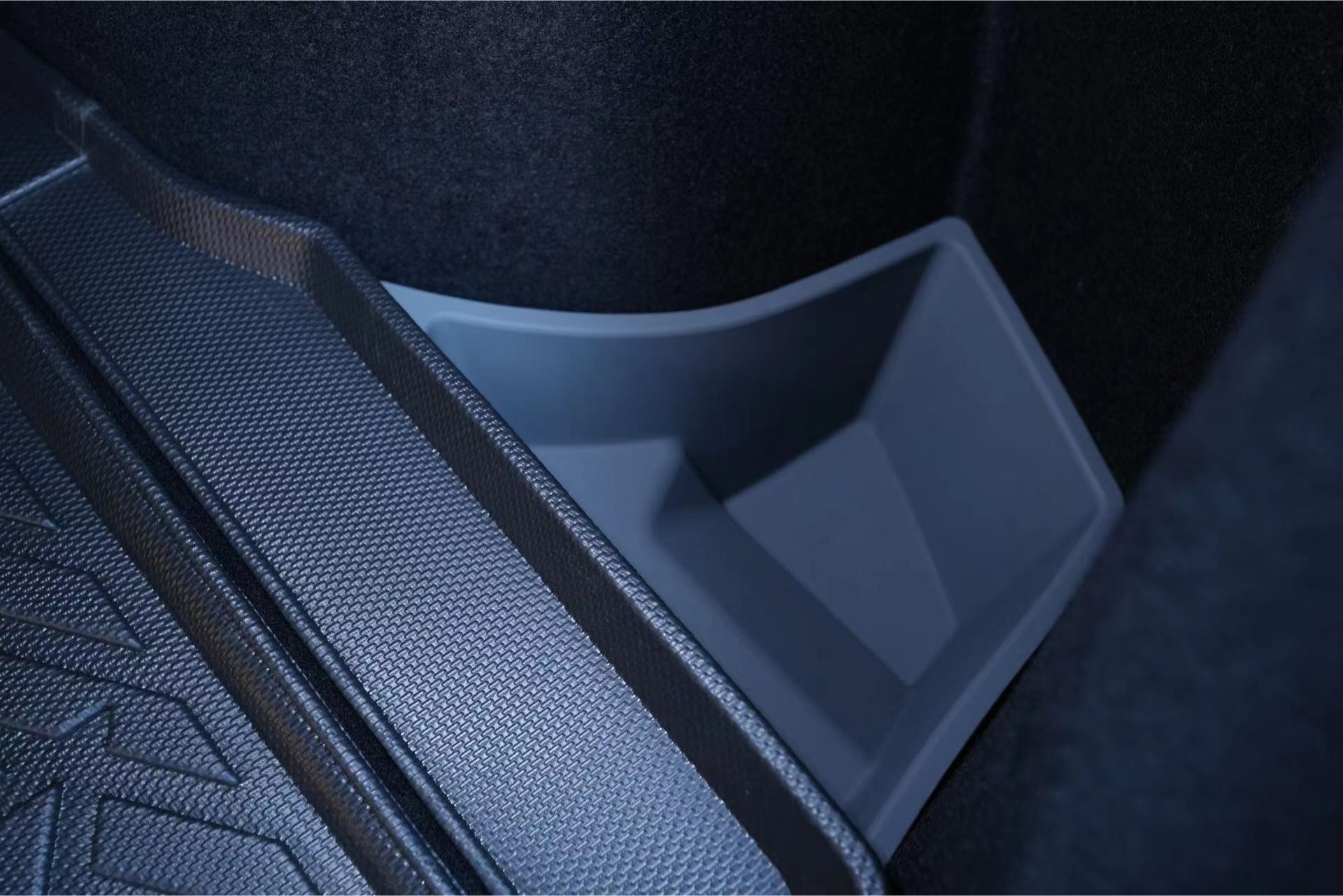 Close-up view of a JOWUA Model 3 All Weather Trunk Combo, designed for the reengineered Model 3 Highland (2024+), featuring a textured mat made from waterproof TPE material and a plastic storage compartment. The compartment is partially visible, expertly shaped to fit snugly alongside the trunk wall, highlighting its practical design.