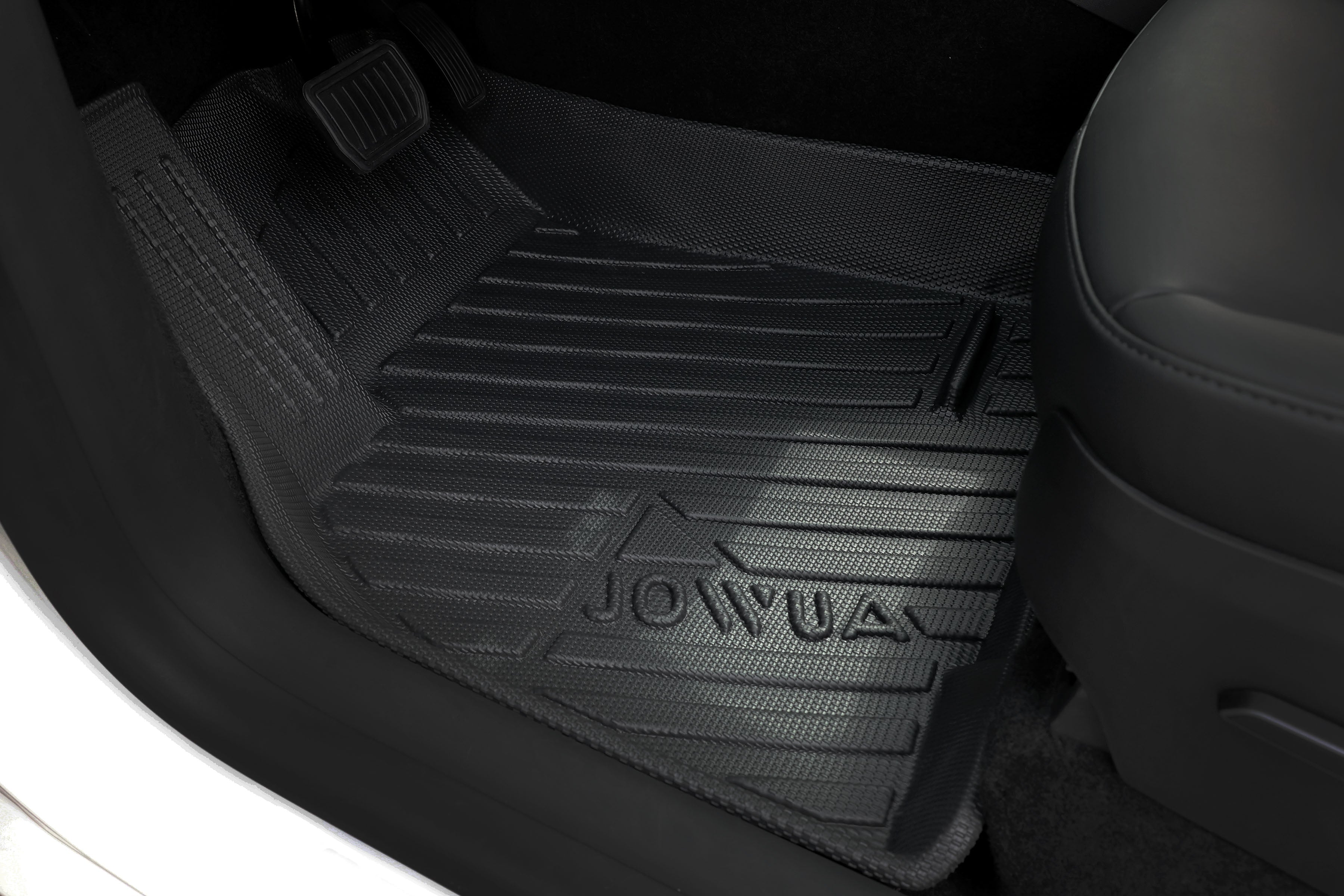 The Tesla Model Y interior boasts a JOWUA all-weather driver's side floor liner, part of the "All Model Y All-Weather Floor Liners Combo." The black mat features grooves, fits snugly under pedals and by the seat, ensuring perfect protection for your ride.